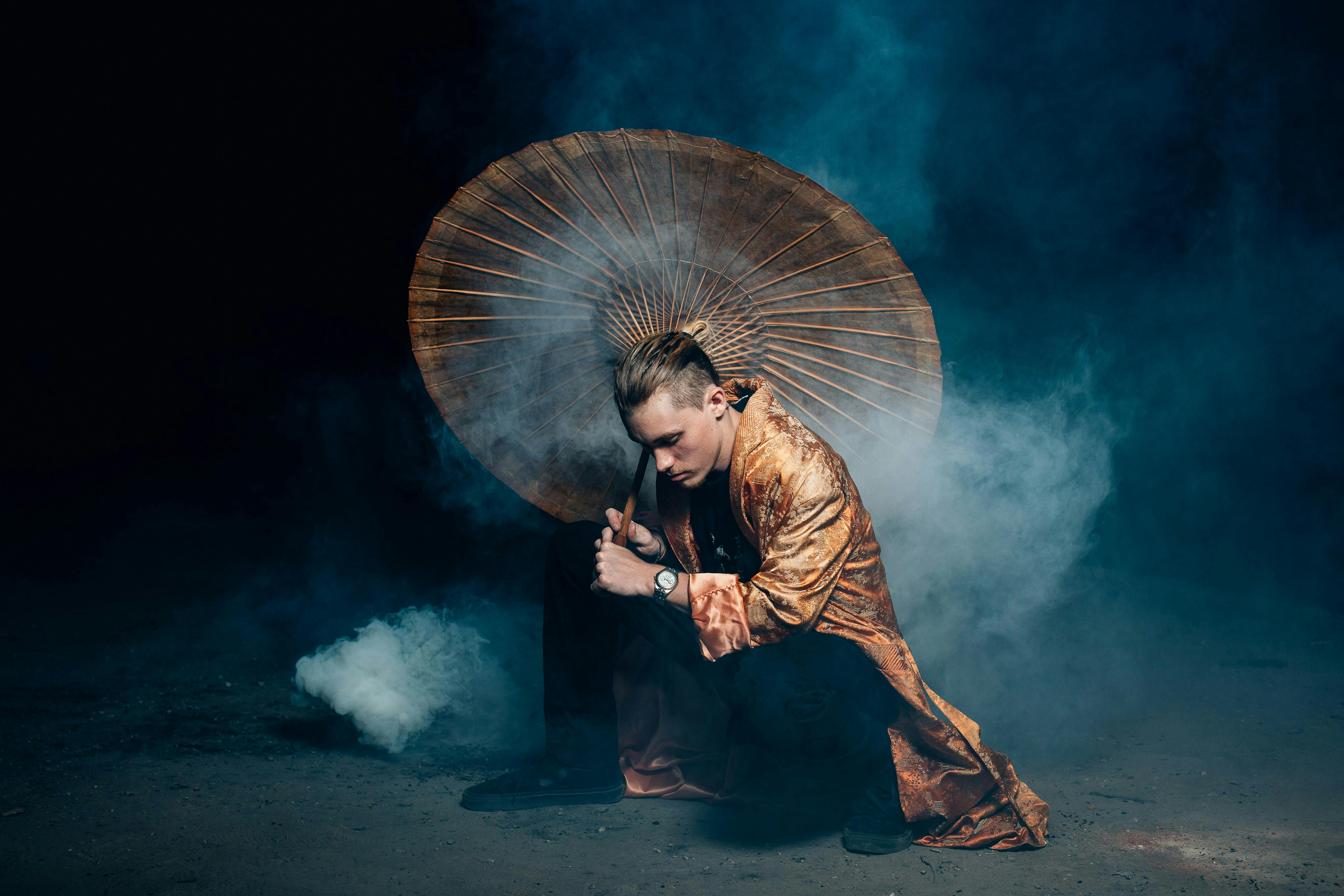 Man Kneeling with Umbrella Smoke